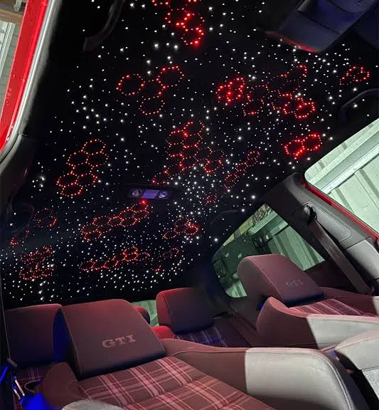 Fiber-optic starlight headliner glowing in a dark vehicle interior
