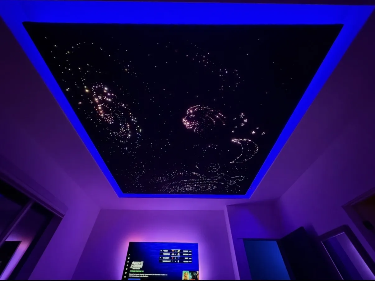 Custom home starlight ceiling with constellations and blue ambient halo above a living room TV