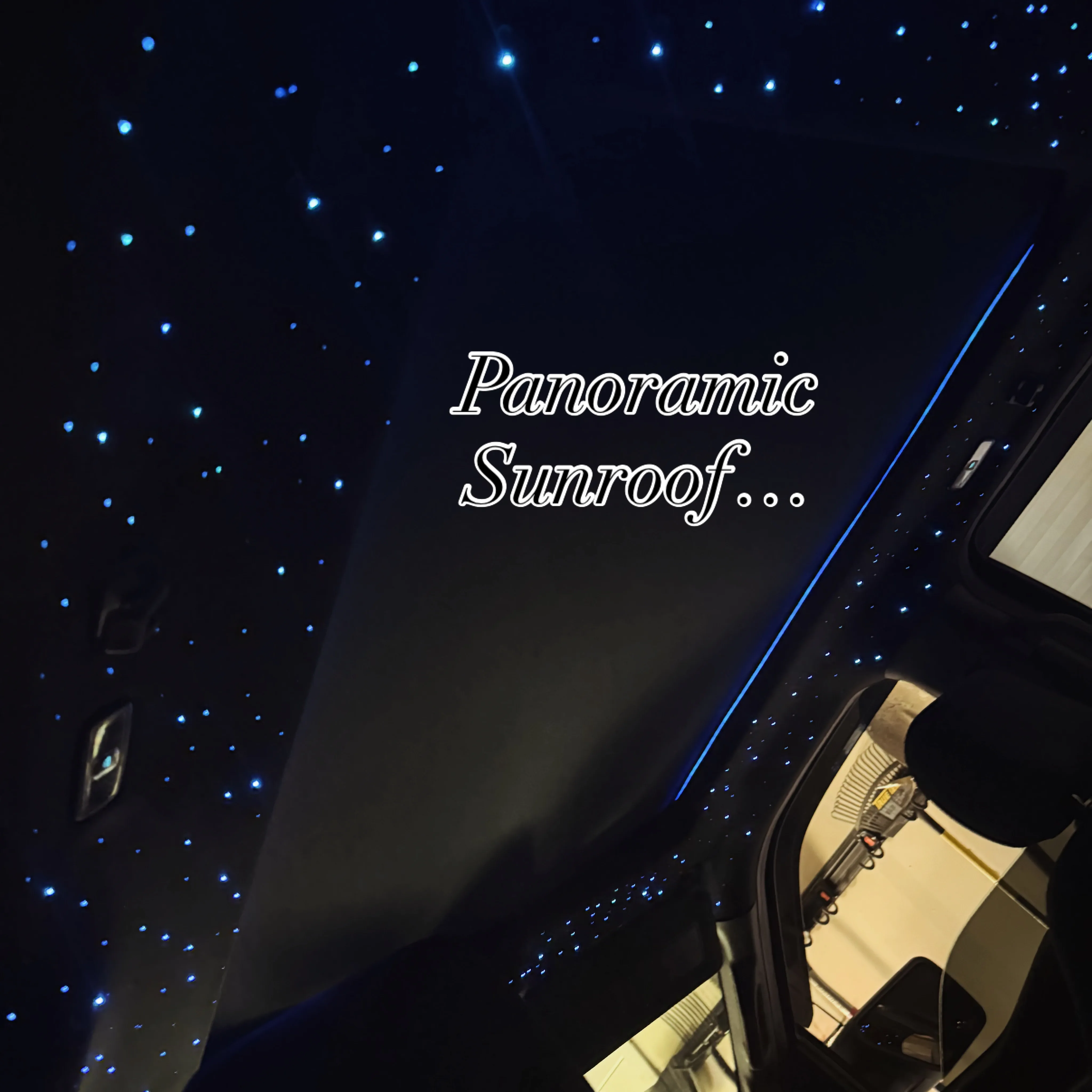 Fiber-optic starlight headliner wrapping around a panoramic sunroof opening with stars covering the full headliner